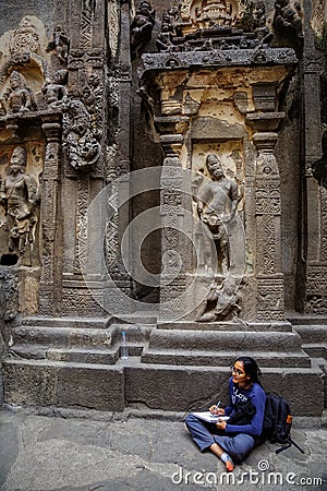 Ellora, Maharashtra, INDIA - JANUARY 15, 2018: Girl student makes a drawing while in the Kailash Temple Editorial Stock Photo