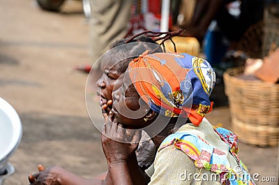 Unidentified Ghanaian women sit in Elmina market and look ahead Editorial Stock Photo