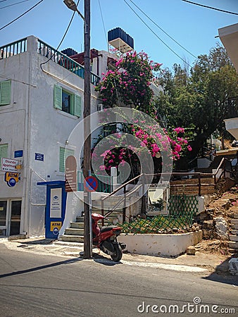 Elounda, Crete, Greece - September 2: Street of a Greek city, a motorcycle is parked. Hotel building. Booth with an ATM. Beautiful Editorial Stock Photo