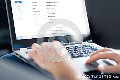 Email inbox full of messages and text. Man reading electronic mail with laptop. Spam, junk and e marketing on screen. Stock Photo