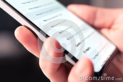 Email inbox in mobile phone with list of new unread messages, marketing newsletters and spam. Person looking at digital mail. Stock Photo