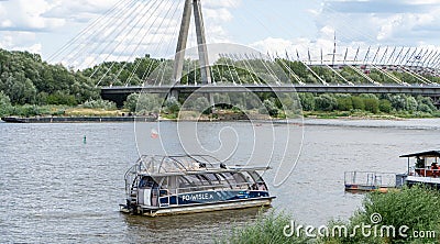 Embankment of the Vistula River in Warsaw. The ship is sailing. View of the bridge and the stadium. Sky with clouds. Editorial Stock Photo