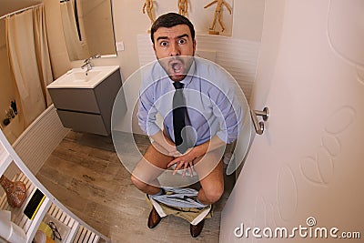 Embarrassed businessman caught in the toilet Stock Photo