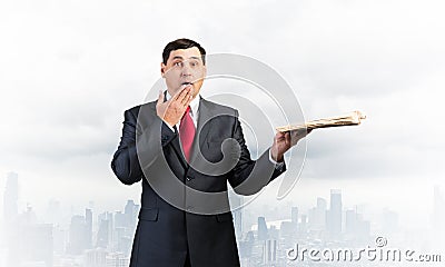 Embarrassed businessman covering mouth with hand Stock Photo