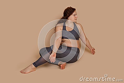 Embarrassed woman sitting on floor, looking side with open arms hands positions, half turn. Fitness gaining weight Stock Photo