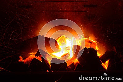 Embers of coal burning. Orange flames blaze in the fire. Bright orange grid nature brand. Burning embers of hot red color. Stock Photo