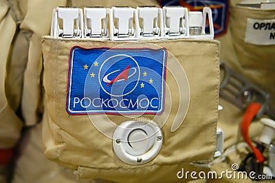 The emblem of Roscosmos on the suit of the astronaut with the ISS. Roscosmos inscription - text on a space suit. Exhibition Days Editorial Stock Photo