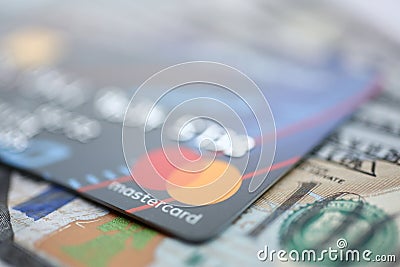Embossed chipped mastercard credit card and hundred dollar bank notes closeup Editorial Stock Photo