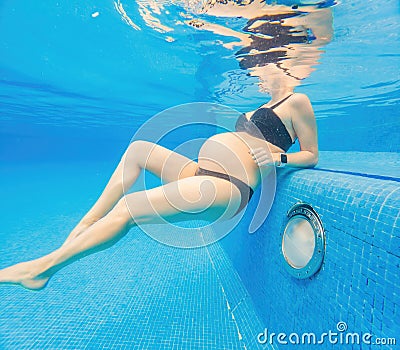 Embracing aquatic fitness, a pregnant woman demonstrates strength and serenity in underwater aerobics, creating a serene Stock Photo