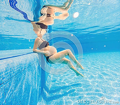 Embracing aquatic fitness, a pregnant woman demonstrates strength and serenity in underwater aerobics, creating a serene Stock Photo