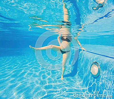 Embracing aquatic fitness, a pregnant woman demonstrates strength and serenity in underwater aerobics, creating a serene Stock Photo