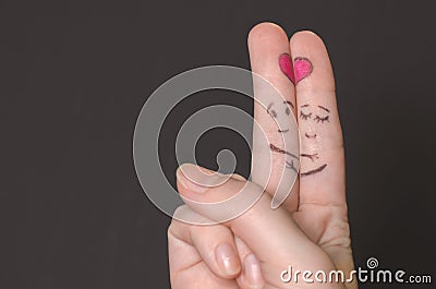 Embracing the fingers with sketched faces Stock Photo