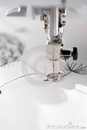 embroidery with embroidery machine - dandilon on white leatherette - macro detail view in bright sunny light mood Stock Photo