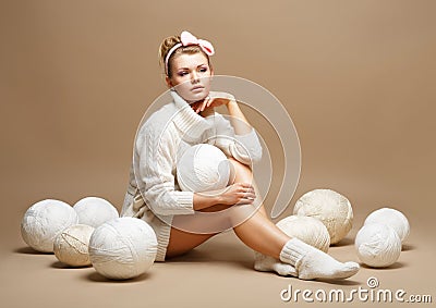 Embroidery. Woman sitting in White Cotton Knitwear with Heap Balls of Yarn Stock Photo