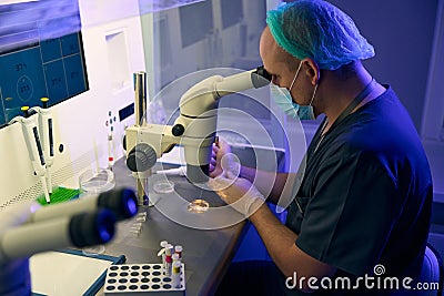 Embryologist researching female cells and preparing them for biopsy Stock Photo