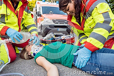 Emergency doctor ventilating injured woman after motorbike accident Stock Photo