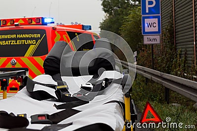 Emergency stretcher stands with a german firefighting truck on freeway Editorial Stock Photo