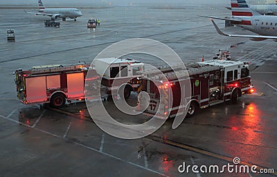 Emergency vehicles, or fire trucks, on tarmac at O`Hare Airport in Chicago in rainy weather Editorial Stock Photo