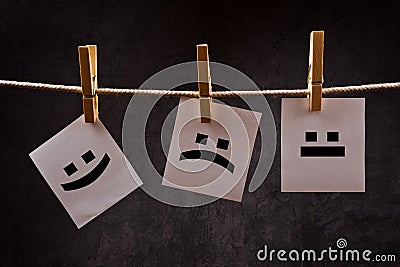 Emoticons on note paper attched to rope with clothes pins Stock Photo