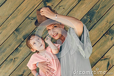Emotion portrait grandmother and his granddaughter in rural style clothers on green wooden background Stock Photo