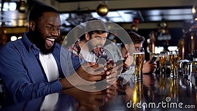 Emotional african-american male celebrating winning bet on match, bookmaker app Stock Photo