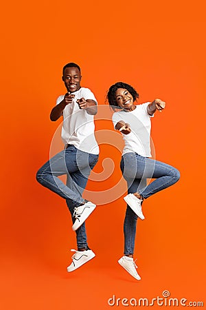 Emotional black couple posing on orange studio background Stock Photo