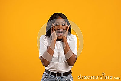Emotional black lady in white t-shirt over yellow background Stock Photo