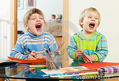 Emotional children playing with paper and pencils Stock Photo