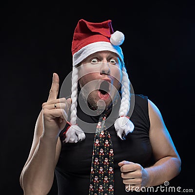 Emotional Comic actor man in cap with braids gesticulates, in anticipation of Christmas and New Year Stock Photo