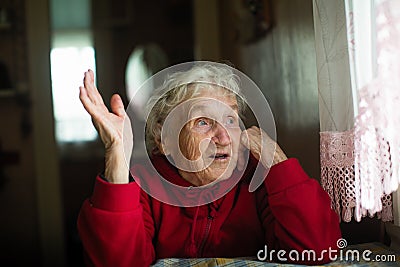 Emotional elderly woman in his home. Help. Stock Photo