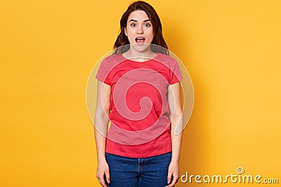 Emotional girl with surprised facial expession, express great admiration, notices desirable thing at shop, posing with open mouth Stock Photo