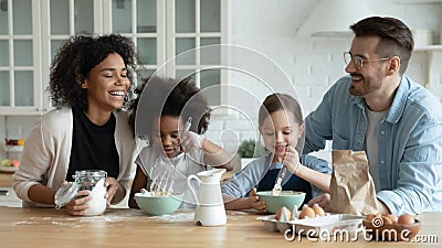 Emotional happy mixed race family preparing weekend breakfast at home. Stock Photo