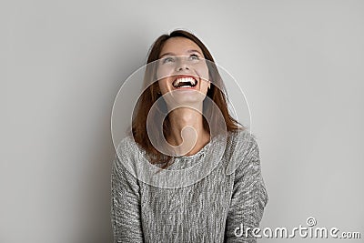 Emotional happy young woman looking up in distance. Stock Photo