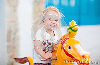 Emotional little girl riding on the carousel Stock Photo