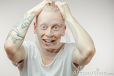 Emotional overjoyed surprised Albino male model with bugged eyes and open mouth. Stock Photo