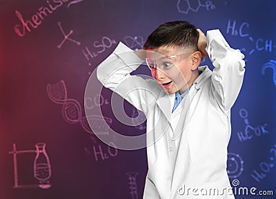 Emotional pupil against blackboard with written chemistry formulas Stock Photo