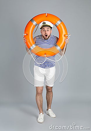 Emotional sailor with ring buoy on light grey background Stock Photo