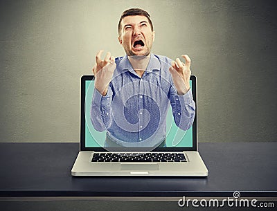 Emotional screaming man got out of the laptop Stock Photo