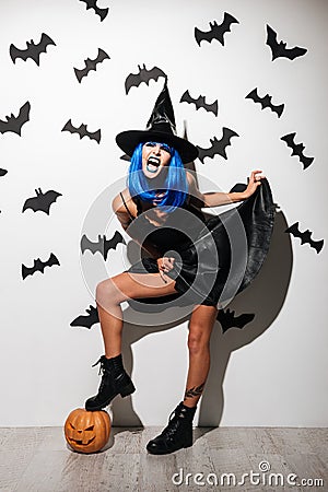 Emotional screaming witch with pumpkin. Looking camera. Stock Photo