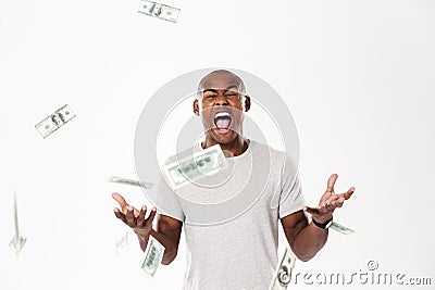 Emotional screaming young african man with money. Stock Photo