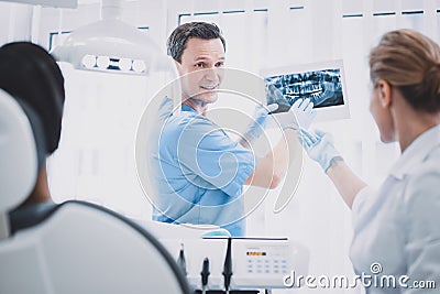 Emotional stomatologist discussing teeth problem with assistant Stock Photo