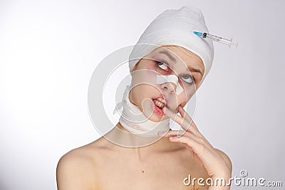 emotional woman bandaged face the syringe sticks out in the head light background Stock Photo