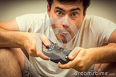 Emotional young addicted man playing video games Stock Photo