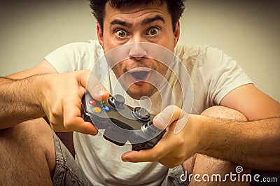 Emotional young addicted man playing video games Stock Photo