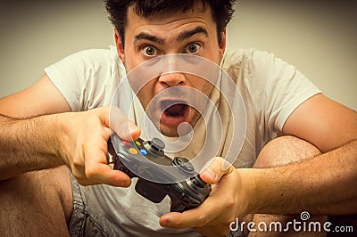 Emotional young addicted man playing video games Stock Photo