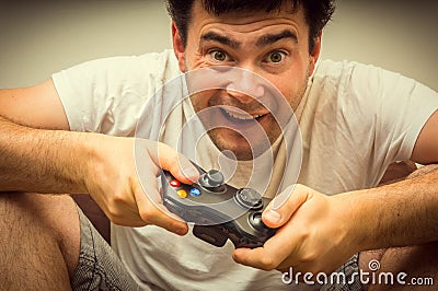 Emotional young addicted man playing video games Stock Photo