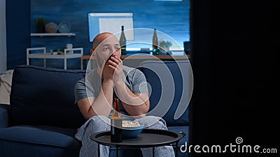 Emotional young guy watching disgusting tv program movie Stock Photo