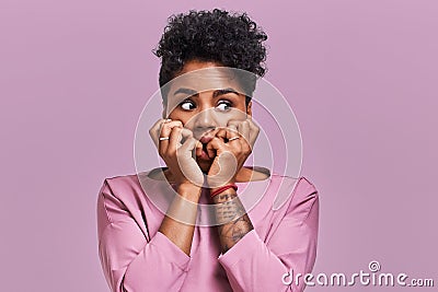 Emotions concept. Nervous emotional scared young lovely African American female stares at camera and opens mouth widely Stock Photo