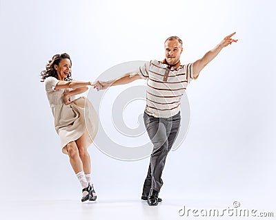 Dynamic portrait of emotional man and woman dancing sport dances on white background. 50s, 60s ,70s american Stock Photo