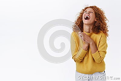 Emotive, happy redhead woman with curly hair, laughing out loud, lift head up, close eyes, cant stop chuckling, clasp Stock Photo